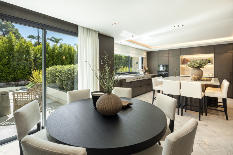 Cocina y comedor de planta abierta en esta villa de Marbella, con puertas correderas a la terraza