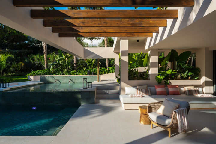 Terrasse couverte au bord de la piscine d'une villa à Nueva Andalucia, Marbella, avec assises et poutres en bois