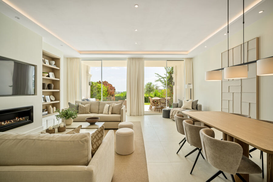 Salón y comedor de planta abierta en una casa adosada en La Quinta con puertas correderas a la terraza