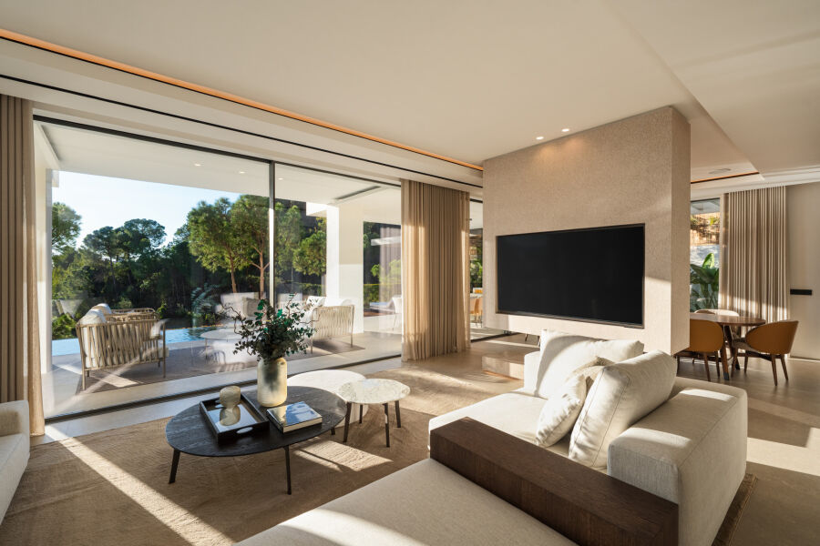 Living room in a La Quinta villa with large sliding glass doors opening to the pool and trees