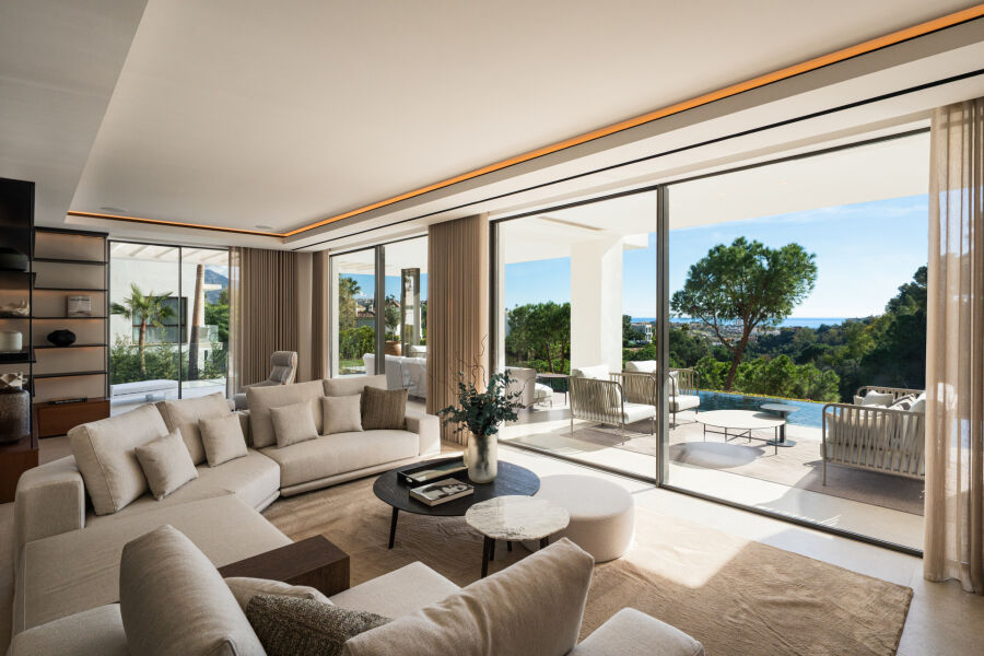 Open-plan villa living room in La Quinta, Benahavis with beige seating and sliding glass doors to a terrace and pool