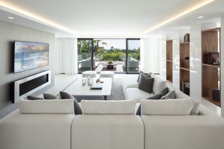 Bright living room in a villa in Nueva Andalucia, Marbella, with sofas, TV wall and sliding doors to the terrace