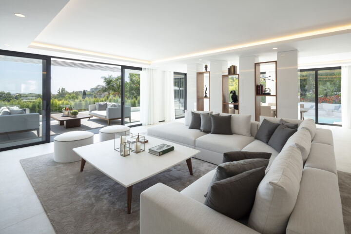 Bright open-plan living room in a Nueva Andalucia villa with sliding glass doors to the terrace